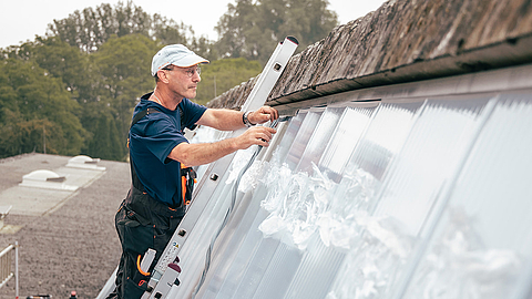 Arbeiter installiert Lüftungssystem auf einem Dach
