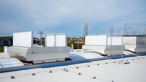 Roof installation with Lichtband B and ventilation units by roda on a flat roof.